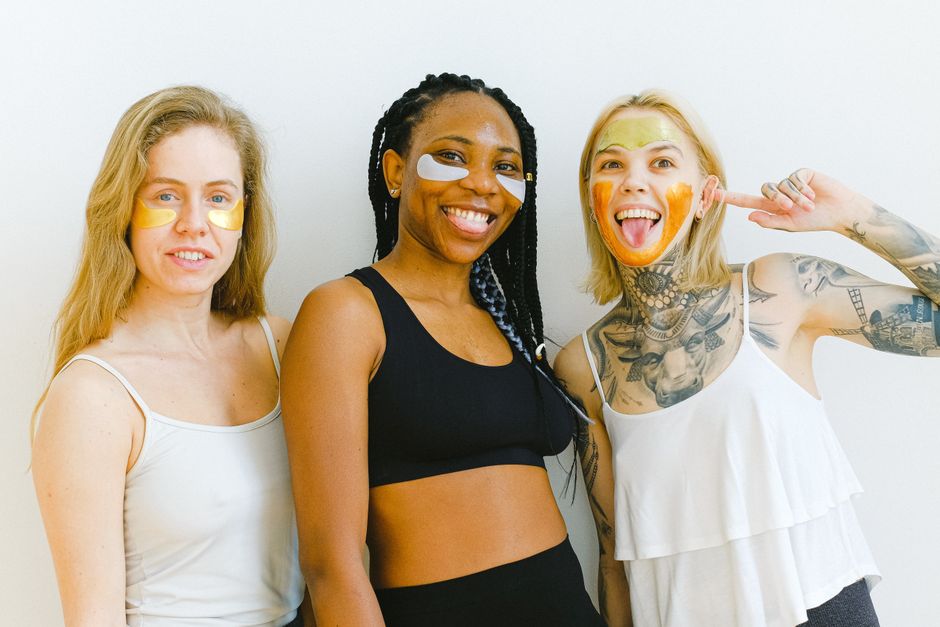 Excited young women smiling and looking at camera while having fun during weekend having beauty procedure